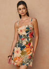Woman wearing a floral dress against a beige background