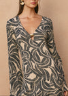 Woman wearing a patterned dress with a beige background
