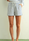 Person wearing blue and white striped shorts on a plain background