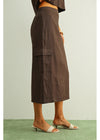 Brown skirt worn by a person on a light green background