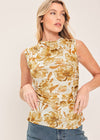Woman wearing a sleeveless top with floral pattern against a plain background