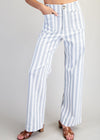 White and blue striped pants worn by a person on a plain background