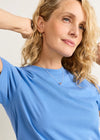 Woman wearing a blue shirt with a plain background