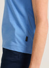 Blue shirt with a brand logo on a neutral background