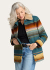 Woman wearing a colorful patterned jacket with a white background