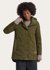 Woman wearing a green parka jacket on a white background