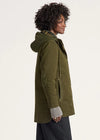 Person wearing a green hooded coat on a white background