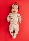 Baby in a floral onesie on a red background
