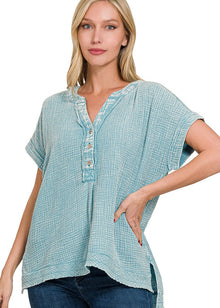  Woman wearing a light blue textured blouse with short sleeves on a white background