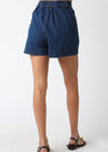 Blue denim shorts worn by a person on a white background