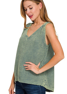  Woman wearing a green patterned sleeveless top on a white background
