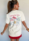Woman wearing a white t-shirt with a graphic design and red shorts against a light background