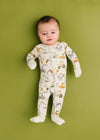 Baby wearing a patterned onesie on a green background
