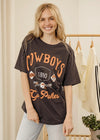 Woman wearing a 'Cowboys Go Pokes' t-shirt in a clothing store.
