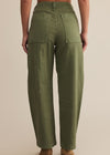 Person wearing olive green pants on a beige background