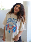 Woman wearing a vintage-style t-shirt with graphic design and text.