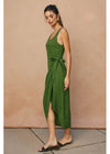 Woman wearing a green dress against a beige background