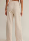 Beige wide-leg pants worn by a person on a neutral background