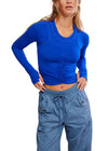 Person wearing a blue long-sleeve top and gray cargo pants on a white background