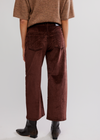 Person wearing brown pants and a matching top on a white background