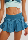 Person wearing blue athletic shorts on a plain background