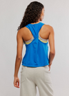 Person wearing a blue tank top with open back design on a plain background