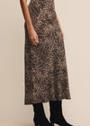 Person wearing a leopard print skirt on a beige background