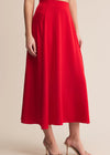 Red skirt worn by a person on a beige background