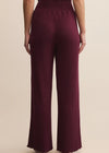 Maroon ribbed pants worn by a person on a beige background