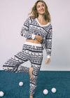 Woman wearing a patterned pajama set on a blue and white background