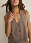 Woman wearing a brown sleeveless top against a neutral background