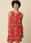 Woman wearing a red floral dress against a beige background