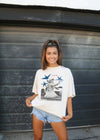 Woman wearing a graphic t-shirt in front of a metallic shutter