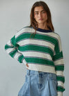 Woman wearing a green and white striped sweater with a gray background