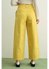 Person wearing mustard yellow wide-leg pants on a plain background