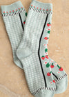 Pair of light blue socks with floral patterns on a beige background