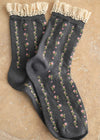 Dark gray socks with floral patterns and lace top on a beige background
