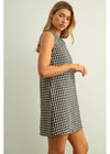 Woman wearing a black and white checkered dress against a light background