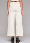 Person wearing white wide-leg pants on a gray background