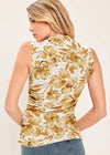 Woman wearing a sleeveless top with a floral pattern on a plain background