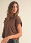 Woman wearing a brown top against a beige background