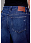 Close-up of blue jeans with a brown leather patch and 'HIDDEN' branding.