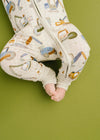Baby legs in patterned pants on a green background