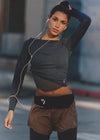Woman in athletic wear with a waist bag on a blurred street background