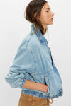 Light blue denim jacket worn by a person on a white background