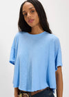 Woman wearing a light blue t-shirt against a white background