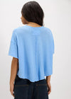 Person wearing a light blue t-shirt and dark jeans on a white background