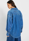 Person wearing a blue denim jacket on a white background