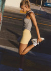 Woman stretching on a city street wearing athletic attire.