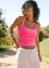 Woman in athletic wear with pink top and white shorts outdoors
